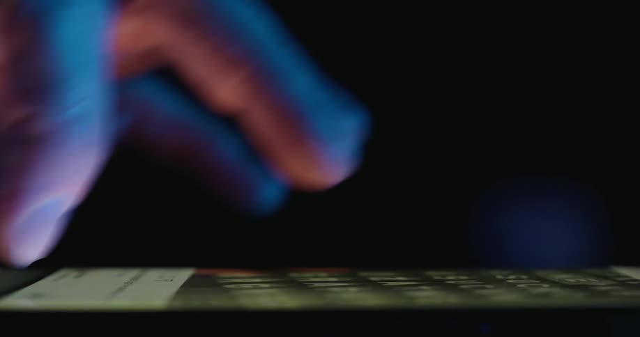 Adult male hand scrolling through text and videos on a smartphone indoors