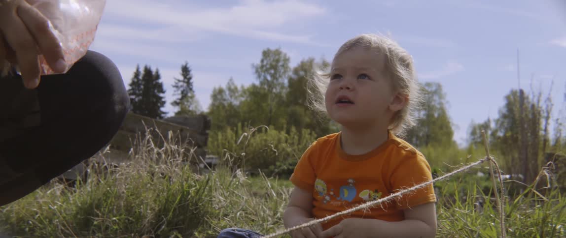 Close up of a woman and child gardening in a bright backyard.