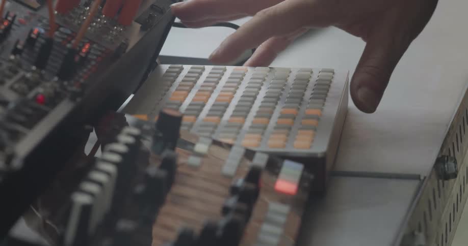 Hand pressing illuminated buttons on an electronic music controller