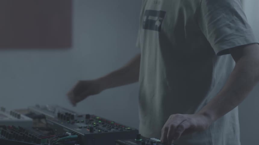 A man using a mixing console to dj