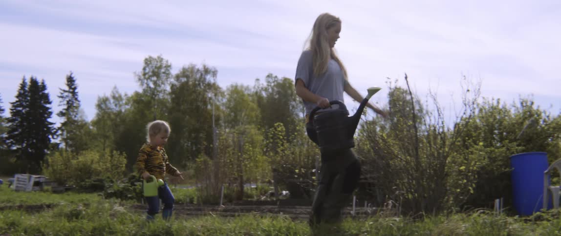 Candid moment of a family walking through a field during a bright afternoon.