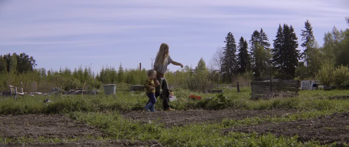 Candid moment of a family working together in a lush green outdoor garden.