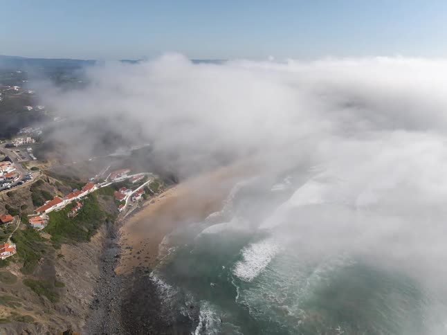 Waves roll onto the beach near a residential neighborhood during the daytime