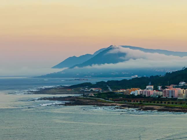 A view of some clouds over a mountain and the coast