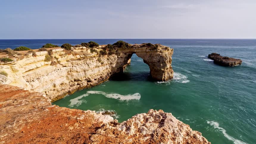 A coastal promontory contains a natural arch