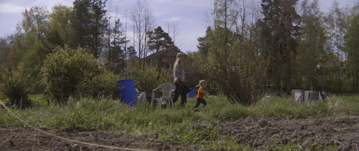 Woman and child play in a yard