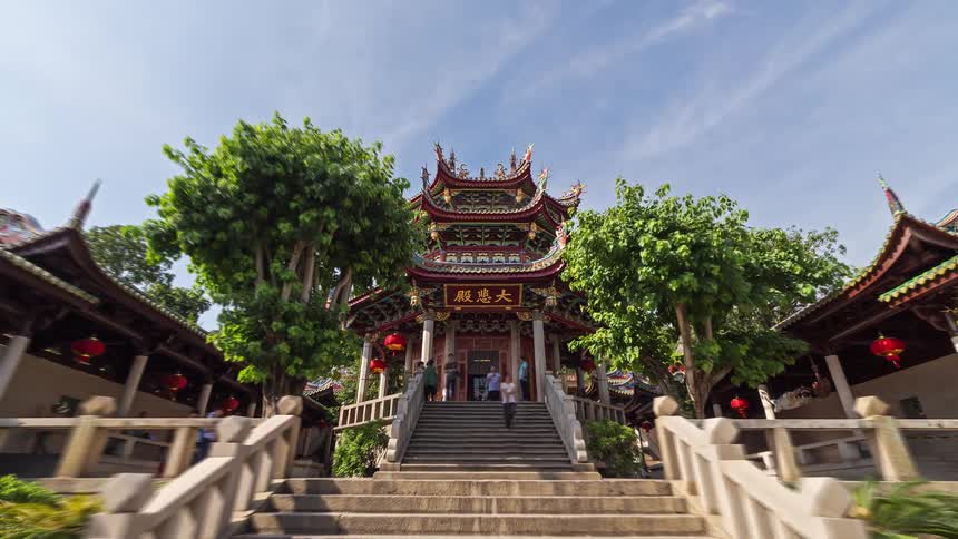 Traditional chinese temple with ornate roof central staircase and trees on both sides