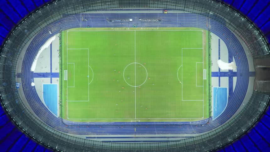 Aerial view of a stadium with a soccer field and running track around it