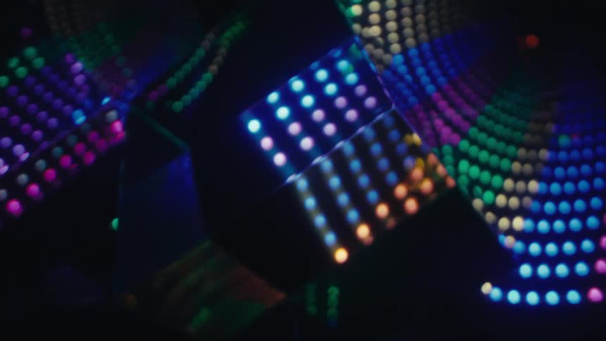 Patterns of colorful lights forming curves and glowing dots in a dark environment