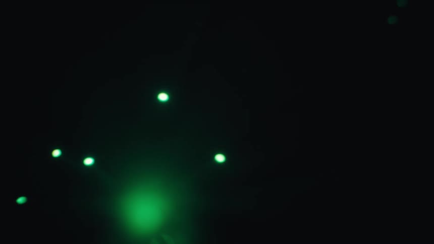 Fiber optic light strands glow and pulse with changing colors against a dark background