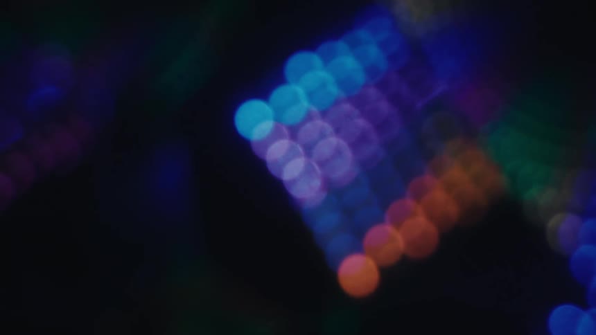 Clusters of orbs of blurry colored lights in the darkness
