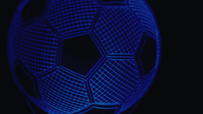 Soccer ball illuminated in blue with a hexagon pattern against a dark background