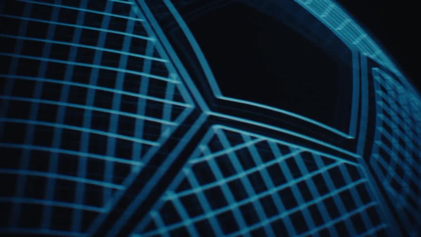 A close view of a glowing blue grid pattern that forms the hexagonal surface of a rotating soccer ball against a black background