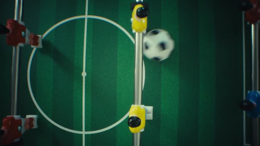 A view of a foosball table with a ball on it