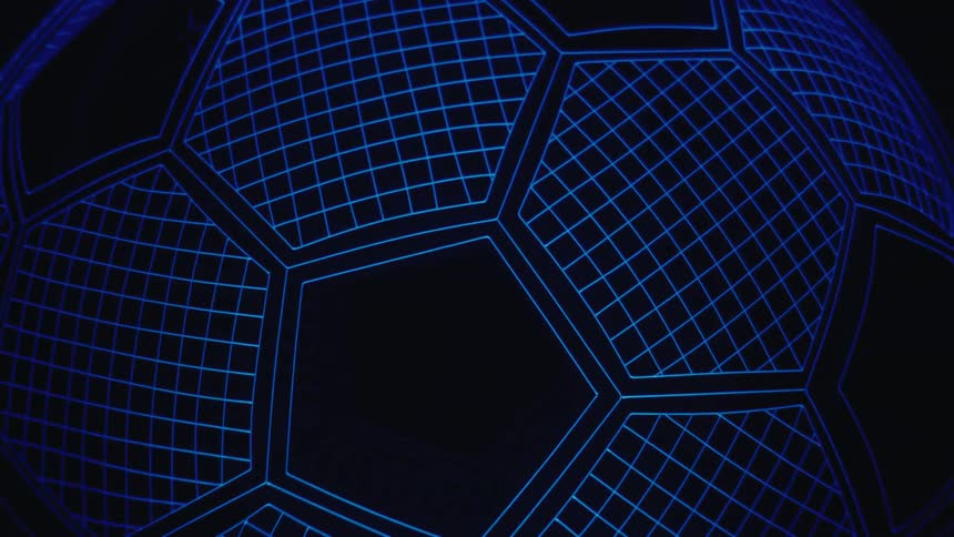 A glowing blue wireframe soccer ball rotates slowly against a black background