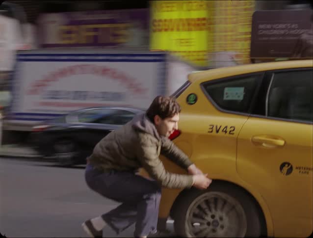 Young adult man wearing a coat and jeans grabbing a taxi while skateboarding on an urban area outdoors during day time