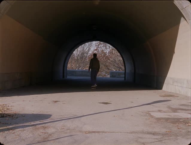 Man performing a skateboard trick in a tunnel