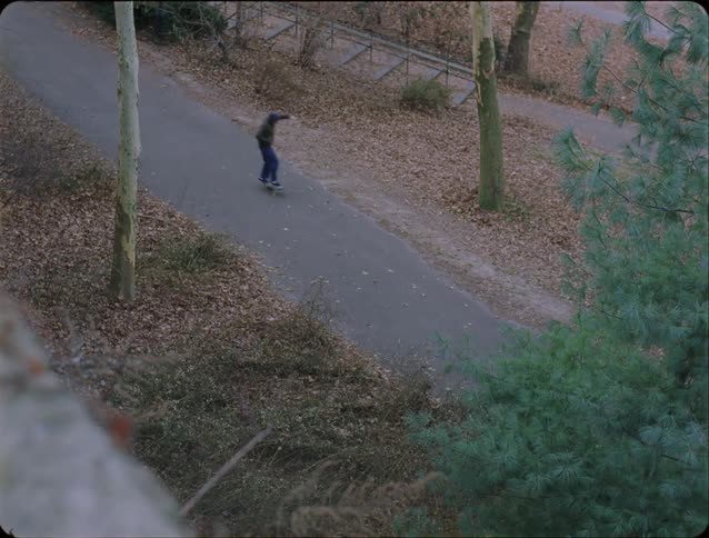 Young man rides his skateboard fast on a street