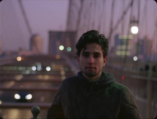 A man standing outdoors on a bridge