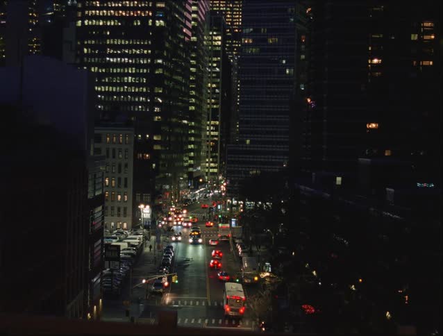 A group of cars driving down a road in a city