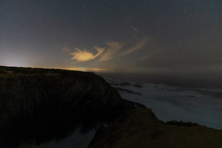 Time lapse of a cliff as ocean waves wash upon the coast below