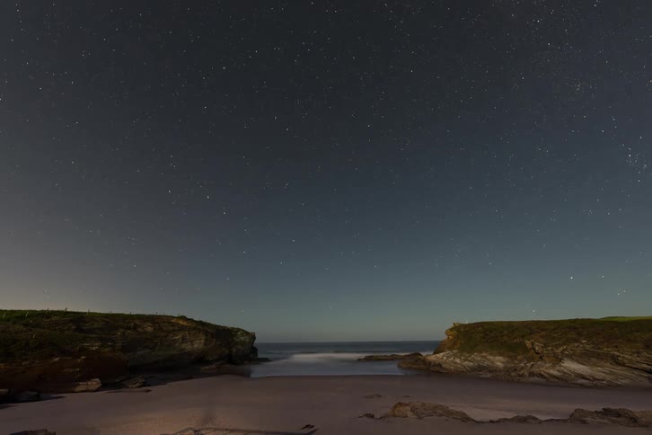 Time lapse of a an ocean beach as dusk becomes night time