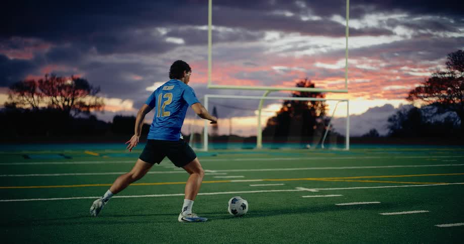 A man kicking a soccer ball on a field