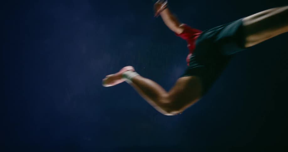 Man makes a long jump under a cloudy sky at night