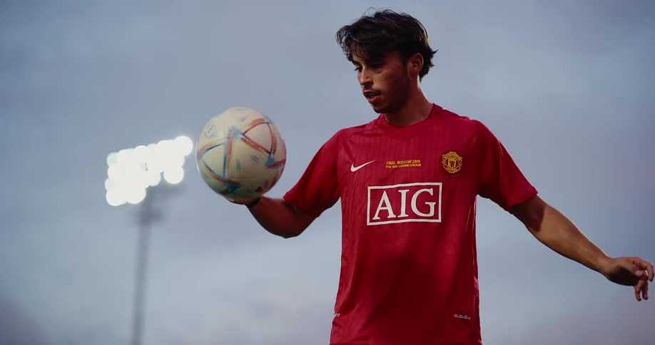A man juggling soccer ball inside the stadium at dusk