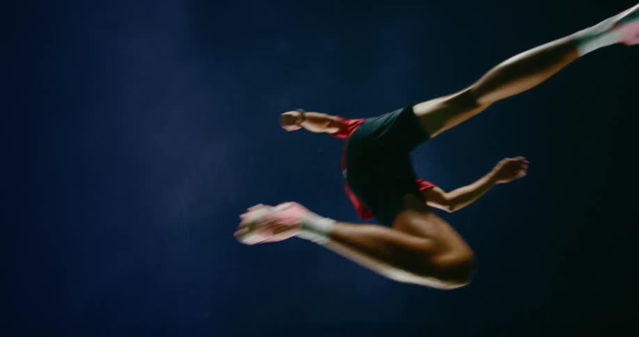 Player jumping in the air on a sports field at night
