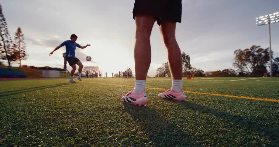 Two young men on the soccer field kicking the ball back and forth