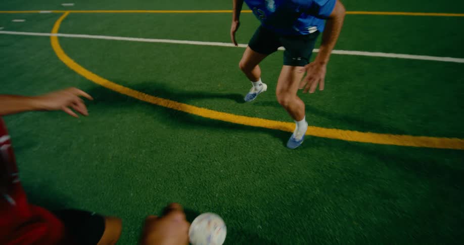 Two soccer players move on the field as one has control of the ball