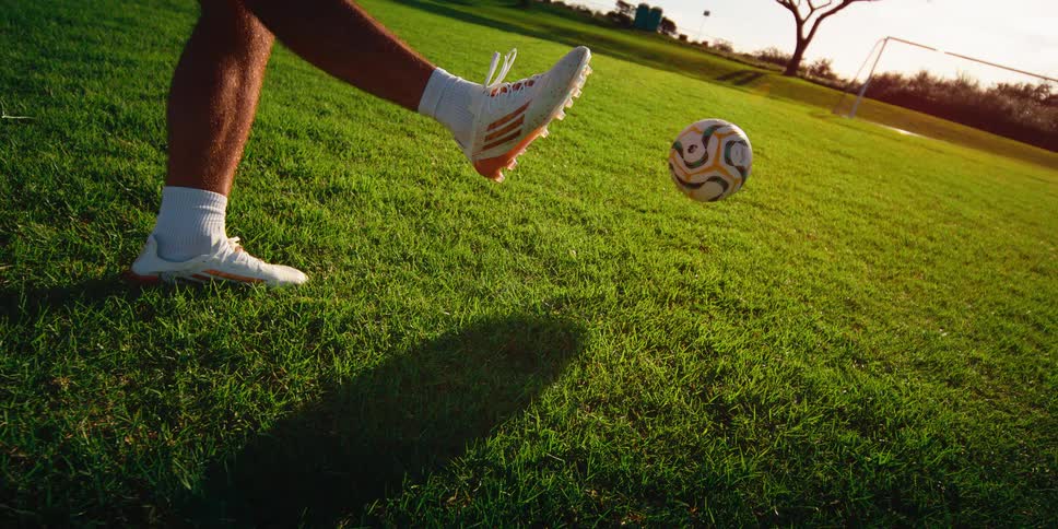 Player kicking a soccer ball toward the goal on a grass field
