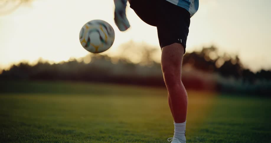 Player juggling a soccer ball on a grass field