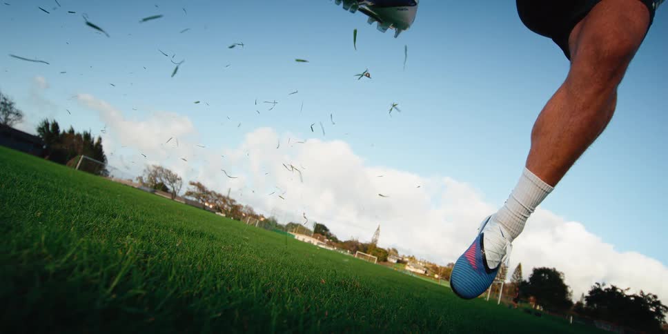 Player kicking a soccer ball with his foot on a grass field