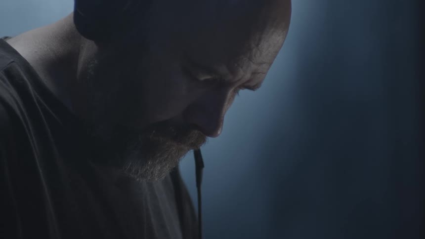A man in a room with a headphone in one ear