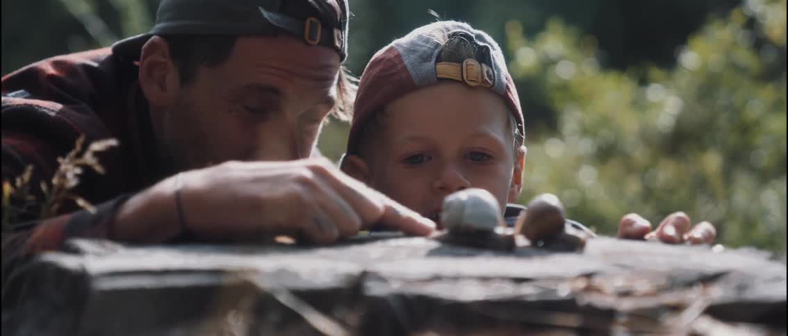 A father and son are looking at snails together