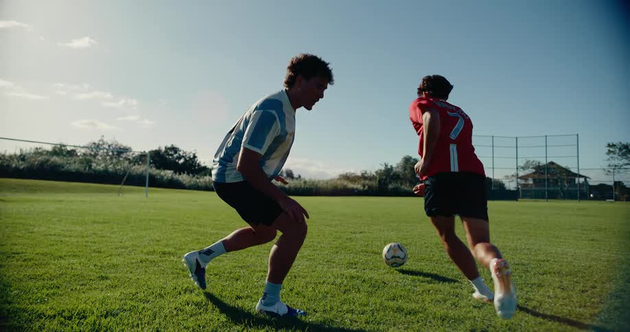 A young man evades another player while practicing soccer