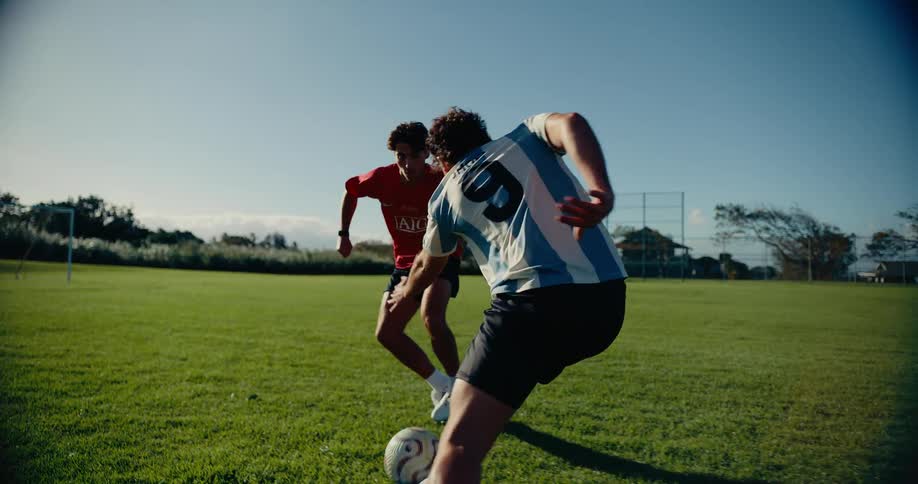 Players contesting the ball during a play on an outdoor grass soccer field