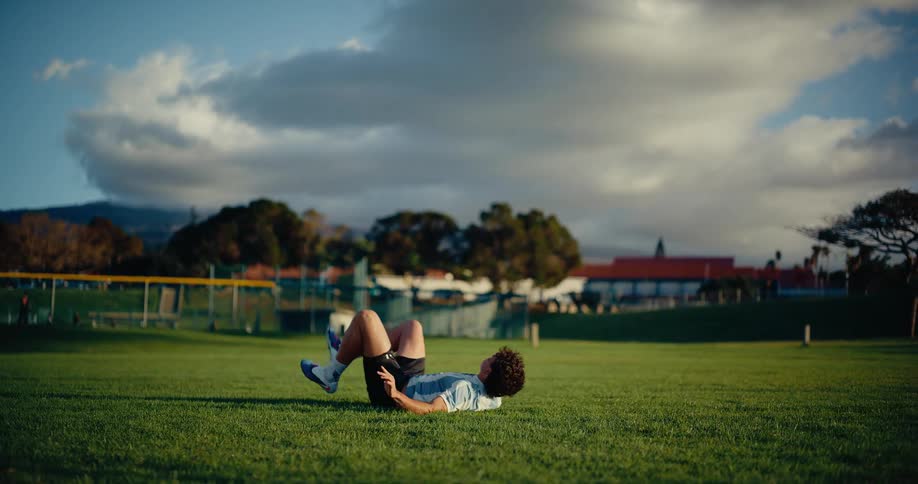 A man performs a jumping bicycle kick on a soccer ball and then falls