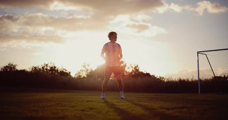 A soccer player jumping in the air on a sunny day