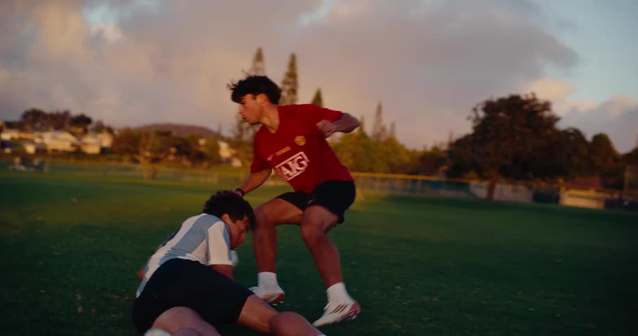 Players contesting a soccer ball during a play on an outdoor grass field