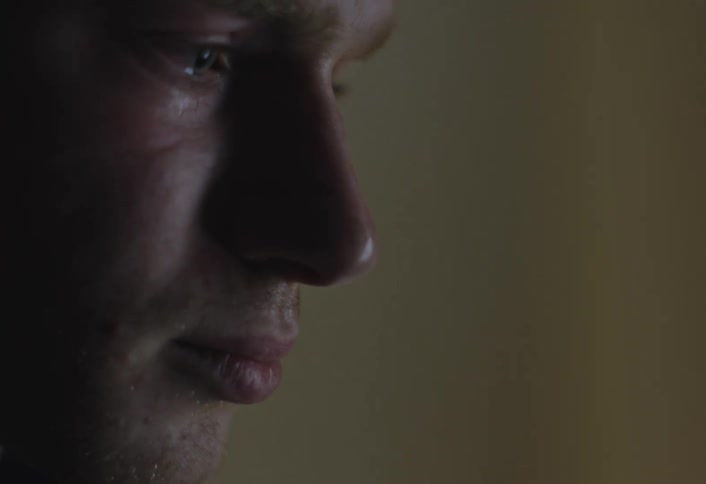 Man closes his eyes sadly before opening them and walking away
