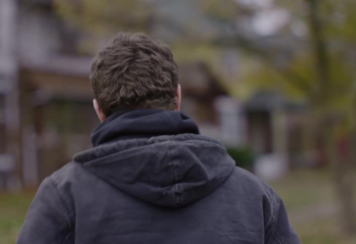 A man walking from a car to a house
