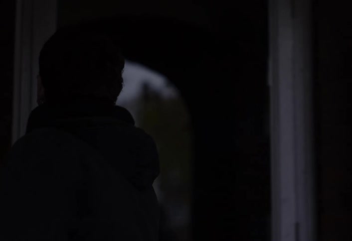 Young man walks to the entrance of a building and walks indoors on an autumn day