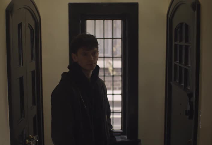 Man enters a house holding an open wooden door