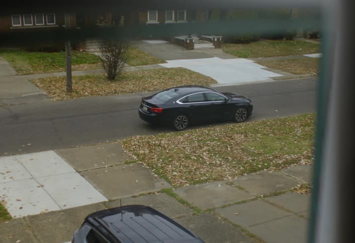 A man arrives home and parks his car on a quiet suburban street in front of residential houses