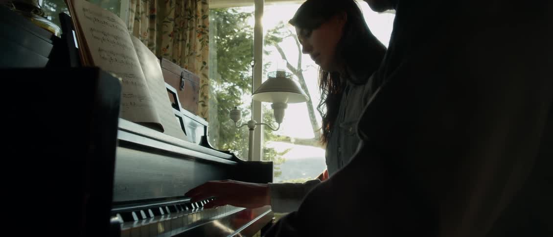 Man and woman play a piano together