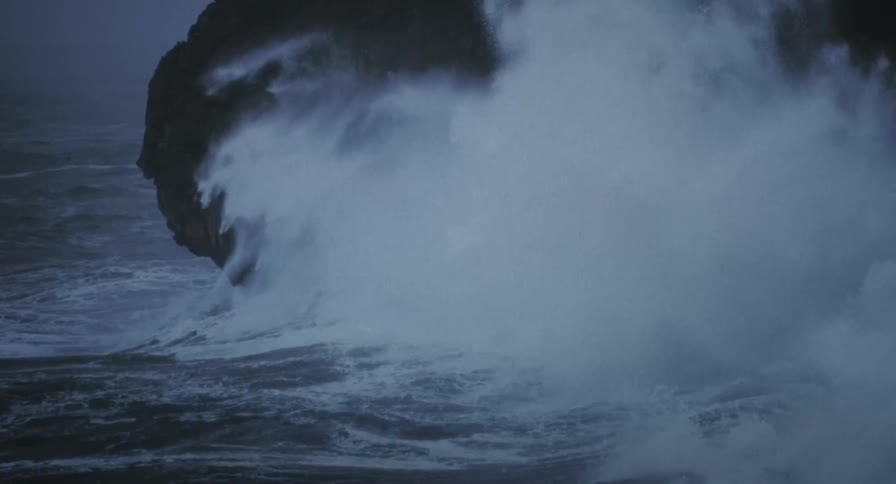 The large wave hits the cliff of the shore