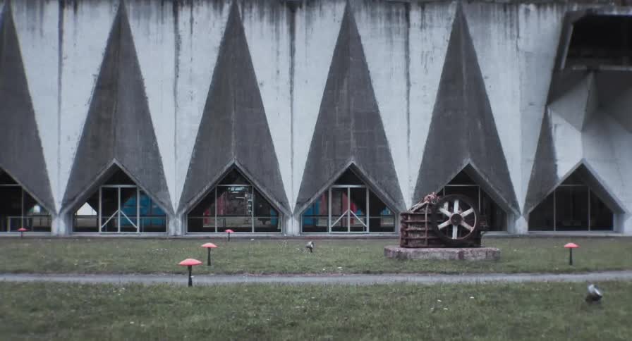 A person walks inside a buildng that has geometric shapes on the exterior